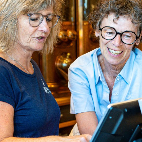 Mitarbeiterinnen schauen in die Kasse