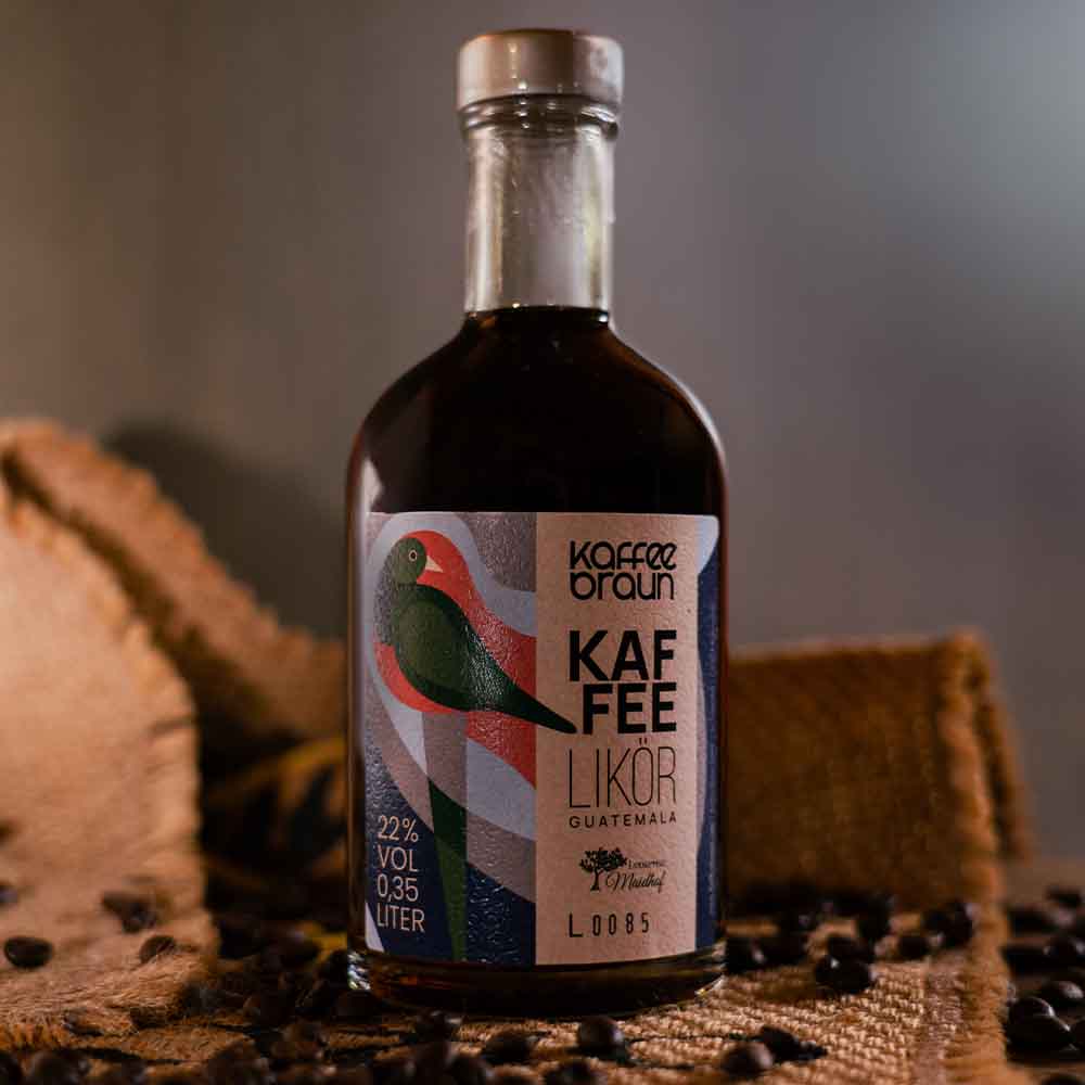 Flasche Kaffeelikör Flasche mit Kaffeelikör mit Kaffeesack im Hitnergrund und Kaffeebohnen verstreut