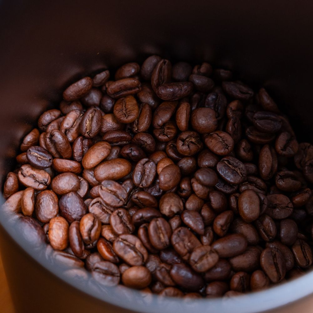 Nahaufnahme frisch gerösteter Kaffeebohnen in einem Röster