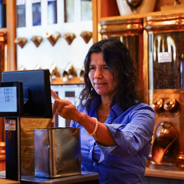 Mitarbeiterin wiegt Kaffee im Röstereiverkauf ab